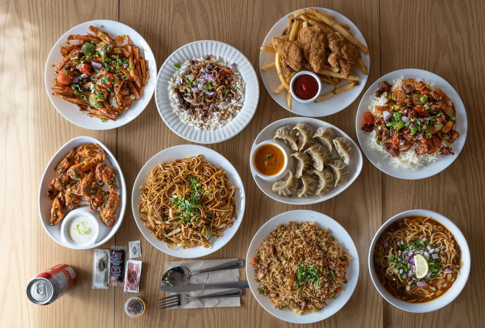 Top view of various Asian and Western cuisine dishes on a wooden table.