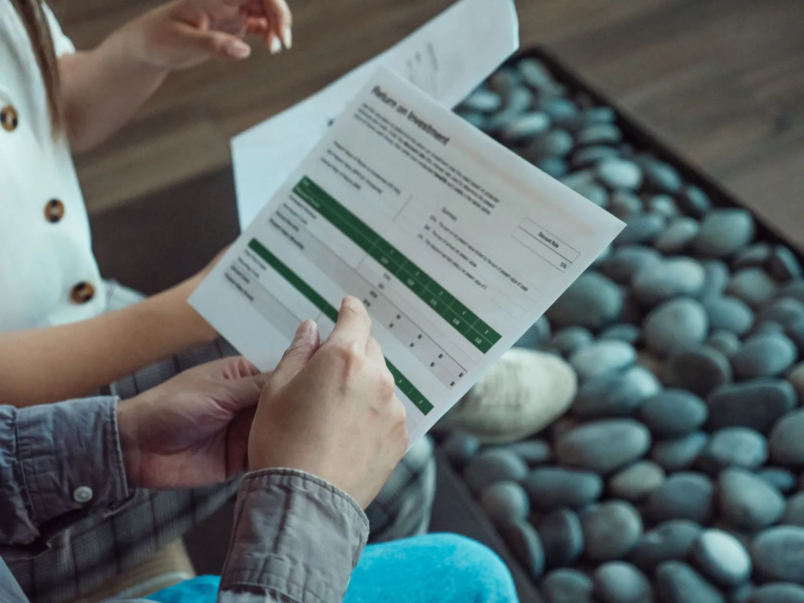 Two people discussing a financial document showing return on investment data.